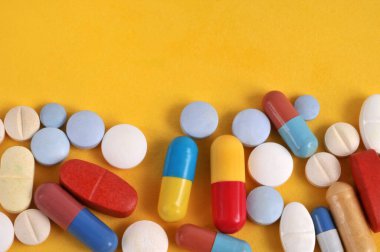 Sarı arka planda ilaçların çeşitliliği 