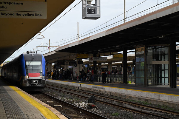 На центральном вокзале Пизы поезд с людьми в ожидании на платформе