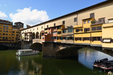 Toskana 'daki Floransa şehrinde Ponte Vecchio' nun altından geçen Arno 'daki tekne.