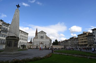 Santa Maria Novella Meydanı 'nda ön planda dikilitaşlardan biri ve arka planda Santa Maria Novella Kilisesi var.