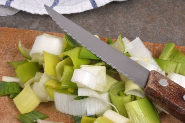 Çiğ pırasa, yakın plan bıçakla parçalara ayrılmış.