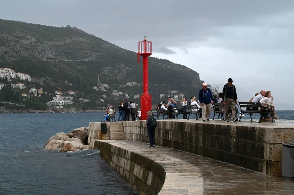 Bulutlu bir günde Dubrovnik limanının girişindeki sette turistler 