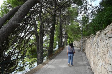 Cavtat kasabasında Setaliste Rat 'in arkasında yürüyen bir kadın.