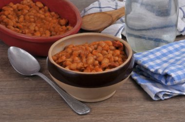 Domates soslu bir kase beyaz fasulye ve yakın plan kaşık.