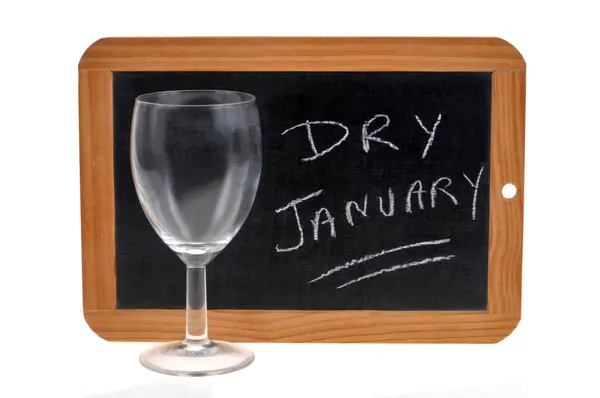 Trockener Januar Mit Schultafel Und Leerem Weinglas Auf Weißem Hintergrund lizenzfreie Stockbilder