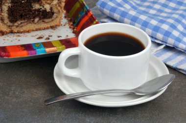 Bir fincan kahve, kaşık ve mermer kek.