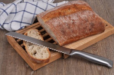 Ekmek tahtasında dilimlenmiş ekmek dilimleri ve yakın plan ekmek bıçağı.