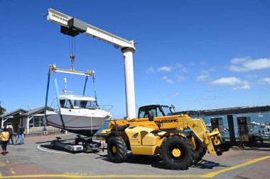 Dinard limanında denize açılmak için liman vinci taşıyan bir tekneyi kaldırmak.