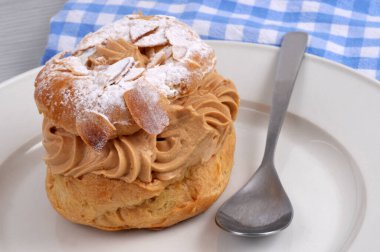 Paris-Brest bir kaşık yakın çekim ile bir tabak üzerinde