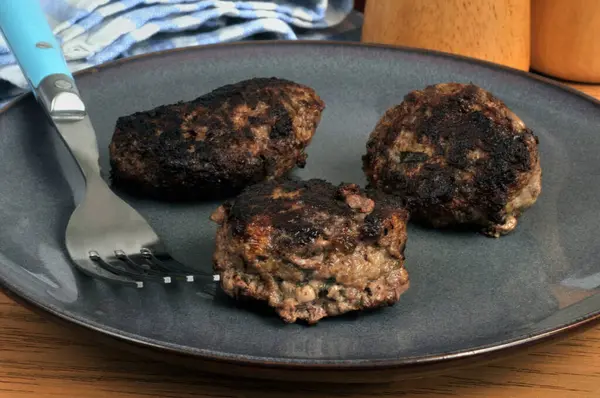 Yakın plan çatallı bir tabakta servis edilen ev yapımı köfteler.