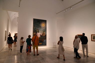 Tablonun önündeki ziyaretçiler 1930-1931 yılları arasında Alfonso Ponce de Leon 'un yaptığı Duraksama adlı resim Madrid' deki Reina Sofia Müzesi 'nde sergilendi.