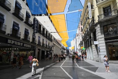 Madrid 'deki yürüyüşçüler Calle de Preciados sokağın karşısına uzanan renkli tuvallerle güneşten korunuyor.