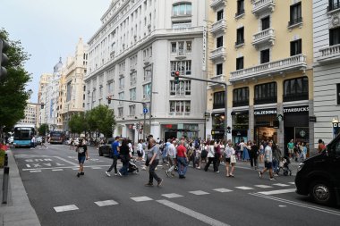 Madrid 'in Gran Via caddesinden geçen insanlar neo-rönesans tarzı binalarla dolu.