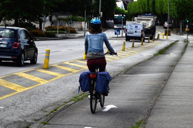 Brittany 'nin Vannes kasabasında bisiklet yolunda kasklı bir kadın bisikletçi.