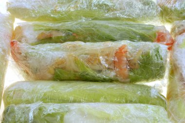 Ev yapımı börekler, arka planda yakın plan çekimde askılı filme sarılmış.