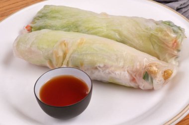 Ev yapımı börek ve arka planda bir kase nuoc mama sosu olan bir tabak.