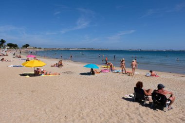 Toulhars sahilindeki turistler Brittany 'deki Larmor-Plage' da