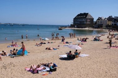 Toulhars sahilindeki turistler Brittany 'deki Larmor-Plage' da