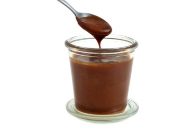 Beyaz arka planda izole edilmiş ramekin bir yakın plan içine ev yapımı tuzlu karamel kaynatmak