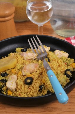 Bir tabak yaz irmiği tavuk, siyah zeytin, mısır ve bir dilim konserve limon.