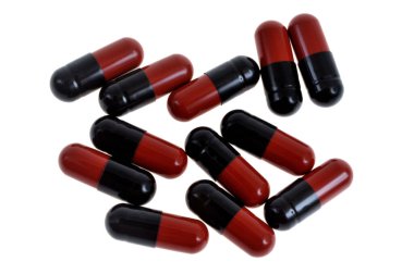 Kırmızı ve siyah kapsüller beyaz arkaplanda izole edilmiş.