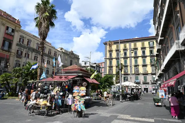 Napoli 'deki Dante Meydanı' nda bir palmiye ağacı ve kafe terasının yanında hediyelik kulübesi var.
