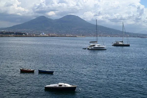 Napoli Körfezi 'nde demirli tekneler ve arka planda Vesuvius volkanı.