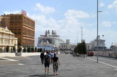 Turistler Napoli 'nin belediye meydanında yürüyor ve limana doğru gidiyorlar.