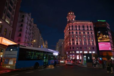 Madrid 'in Gran Via' sındaki otobüsler ve taksiler gece şık binalarıyla