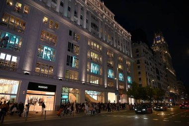 Madrid 'in Gran Via' sında gece dolaşın, şık binalar ve dükkanlarla dolu.