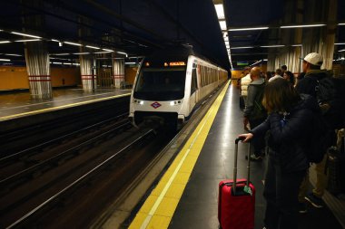 Madrid havaalanı metro istasyonunda bekleyen yolcular.