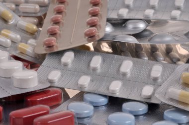 Blister packs of medicine piled up closeup on background clipart