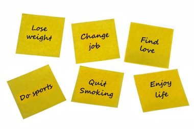 Beyaz arka planda gelecek yıl için iyi kararları olan bir post-it.