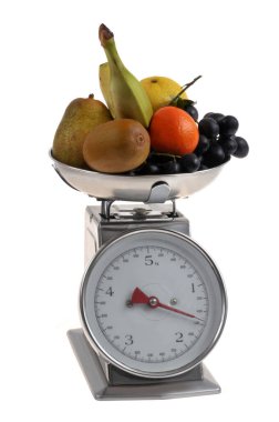 Mutfak ölçeğine göre tartılmış çeşitli meyveler beyaz arka planda izole edilmiş.