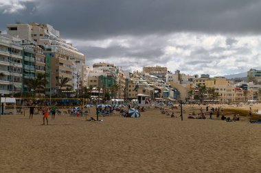 Las Canteras sahilindeki turistler bulutlu gökyüzü ile Las Palmas de Gran Canaria 'da