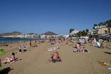 Güneşli bir günde Las Palmas de Gran Canaria 'daki Las Canteras plajında turistler