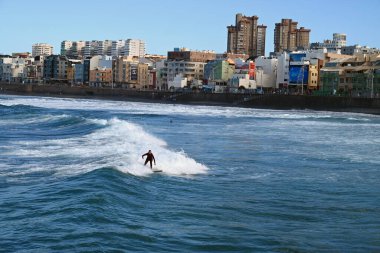 Las Palmas de Gran Canaria 'daki Las Canteras plajında sörf yapan bir sörfçü