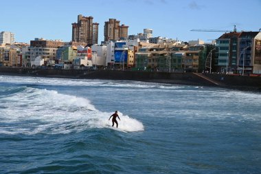 Las Palmas de Gran Canaria 'daki Las Canteras plajında sörf yapan bir sörfçü