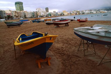 Las Palmas de Gran Canaria 'da bulutlu gökyüzü ile Las Canteras sahilinde tekneler