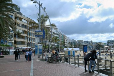 Las Canteras Avlusu 'nda yürüyen turistler binalarla dolu.