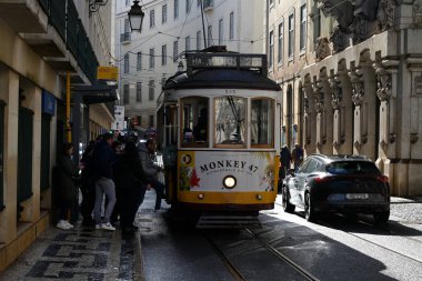 Lizbon 'da bir caddede 28 numaralı tramvay yolcuları, Montant le tramvay 28 Dane une rue de Lisbonne