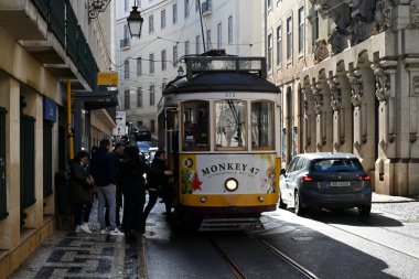 Lizbon 'da bir caddede 28 numaralı tramvay yolcuları, Montant le tramvay 28 Dane une rue de Lisbonne