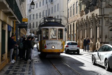 Lizbon 'da bir sokakta 28 numaralı tramvayı bekleyen yolcular 