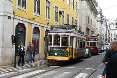 28 numaralı tramvay Lizbon 'da bir caddede giden bir tramvay tramvayı takip ediyor.