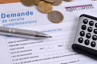 Agirc-Arrco tamamlayıcı emeklilik başvuru formu ile bir hesap makinesi ve avro sikkeleri