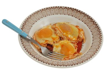 Sobrasada soslu sahanda yumurta tabakta servis edilir. Beyaz arka planda izole edilmiş çatalla yakın plan.