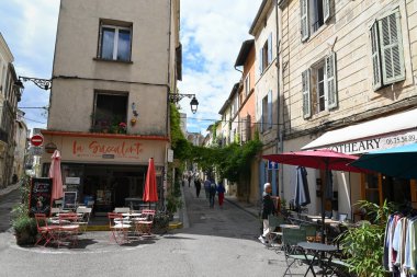 Arles 'teki Voltaire caddesinde gezinen restoran terasları ve turistler.