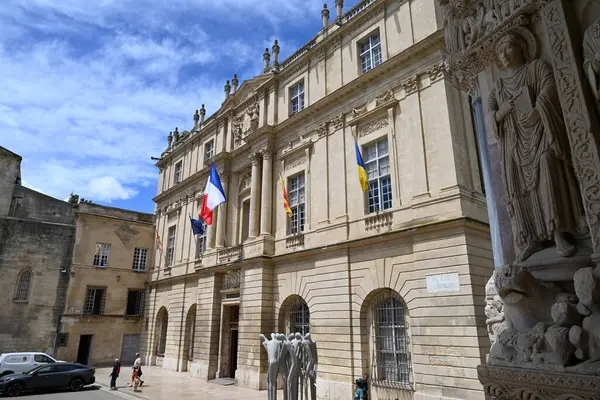 Ön planda Saint-Trophime Katedrali 'nin girişinden heykellerle Arles Belediye Binası cephesi
