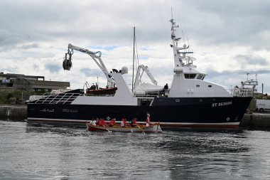 Geleneksel kayık ekibi ile Sete limanında bir ton balığı teknesinin yanından geçiyor.