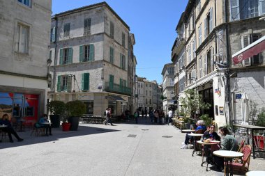 Avigno 'daki Paul Sain sokağındaki bar ve restoranların teraslarında oturan turistler